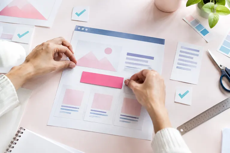 Mains disposant des blocs de papier pour composer la structure d’une page de conversion