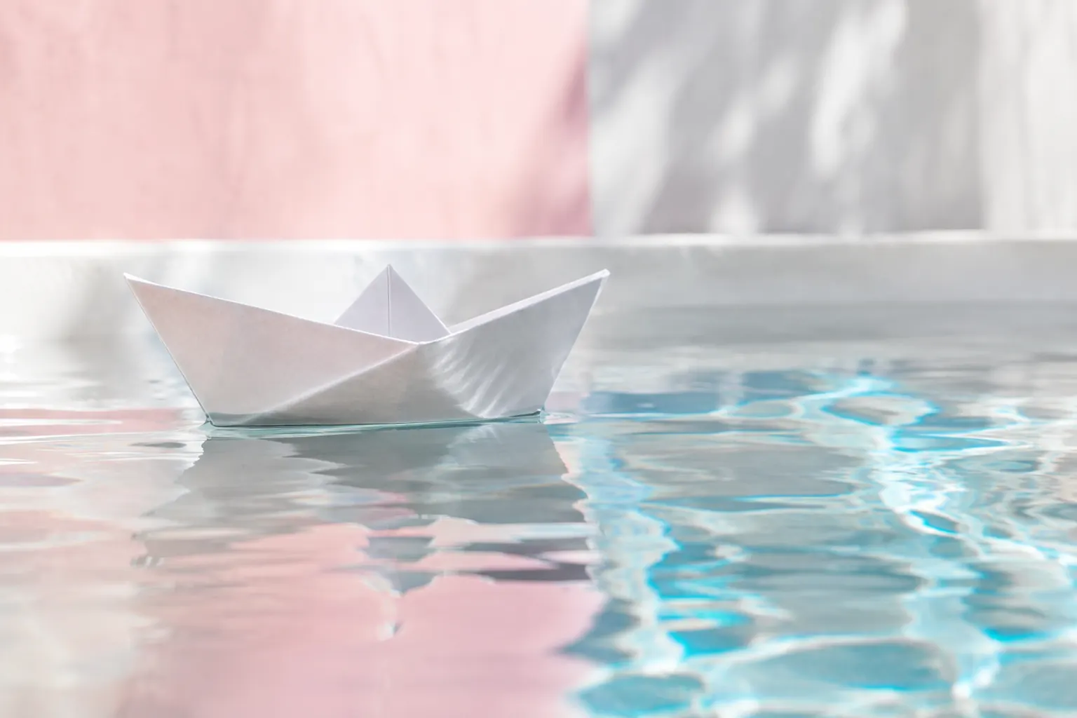 Bateau en papier sur une eau claire, image de ce qu’il faut mettre au-dessus de la ligne de flottaison d’une landing page